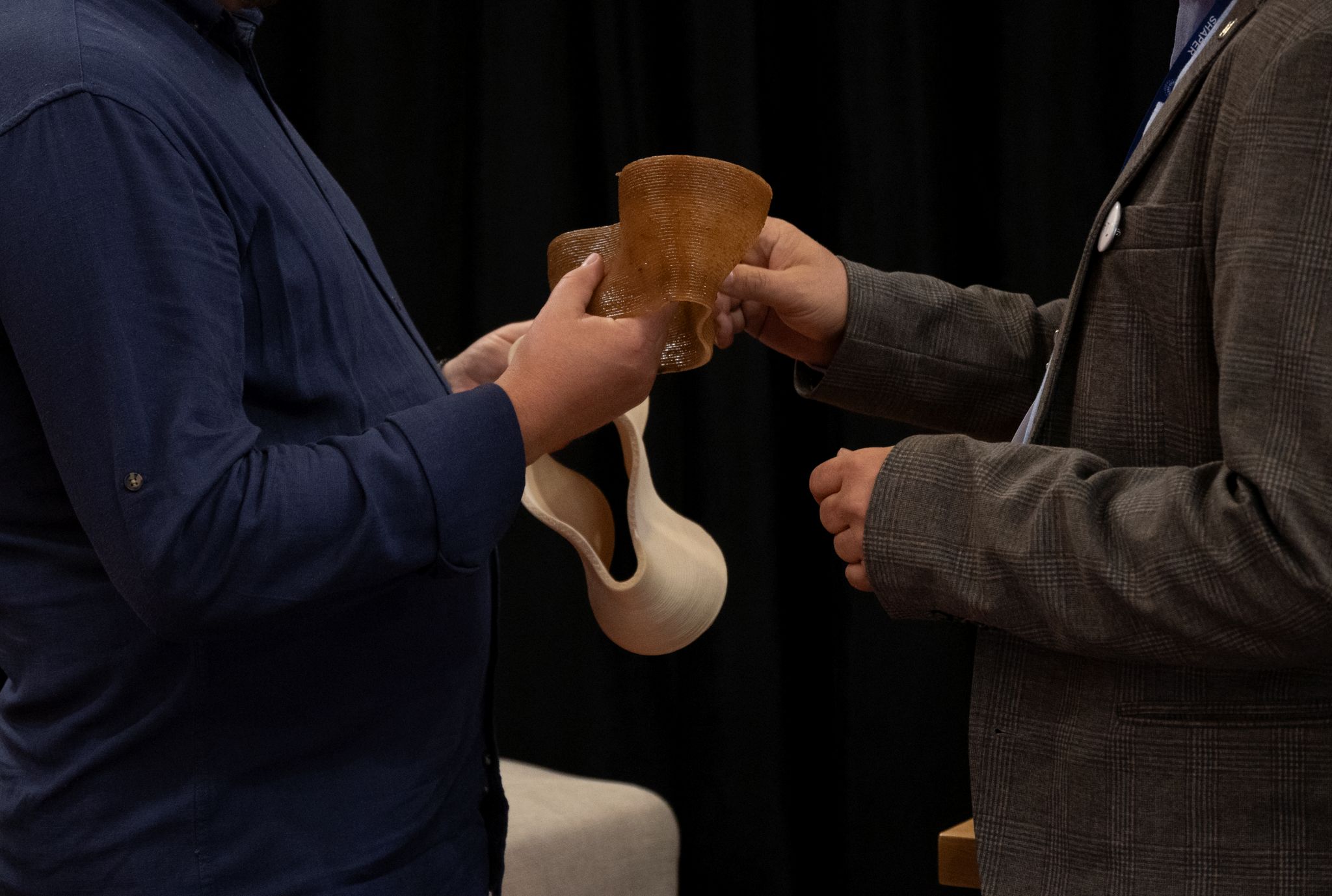 people touching 3D printed samples at BifeSim2026
